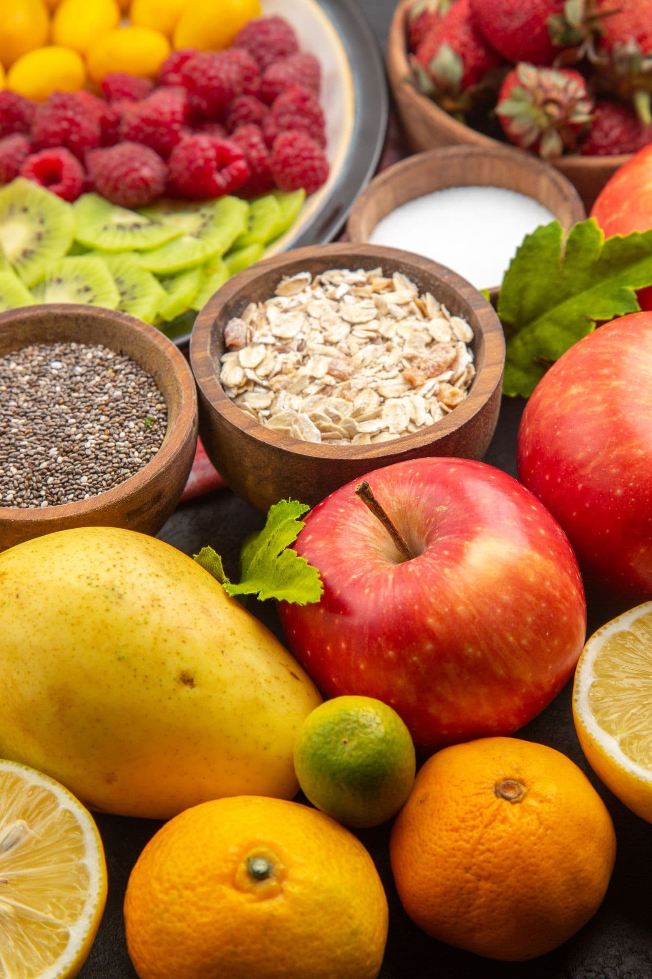 Frutas, avena y semillas en cuencos de madera